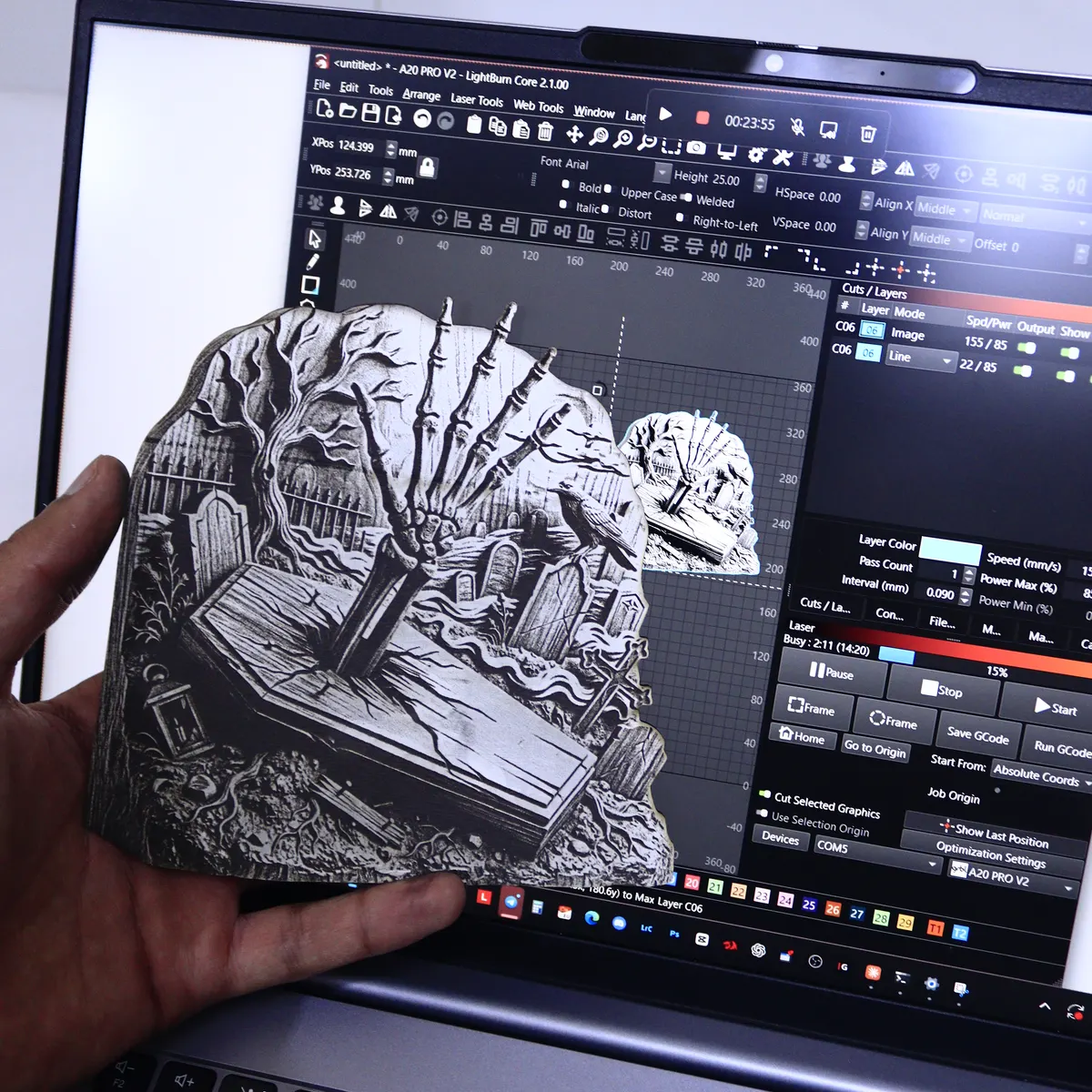 A finished piece engraved and cut from a Studio file, held in front of the same file open in LightBurn